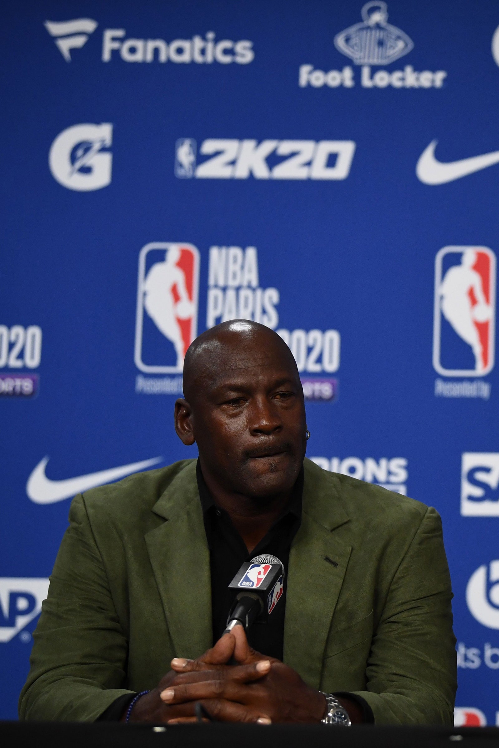 Former NBA star and owner of Charlotte Hornets team Michael Jordan looks on as NBA commissioner Adam Silver addresses a...