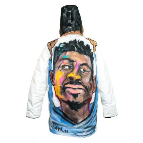 A white Wuxly coat features artwork, a portrait of a Black man, by local Toronto artist Jabari Elliott on the back