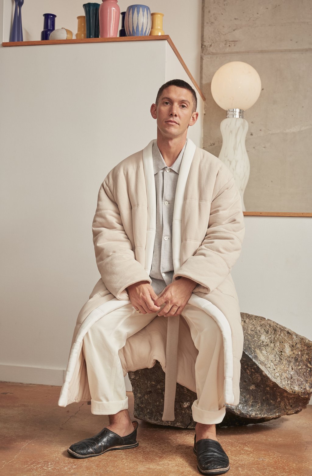 A man sitting down and wearing a giant looking plush robe