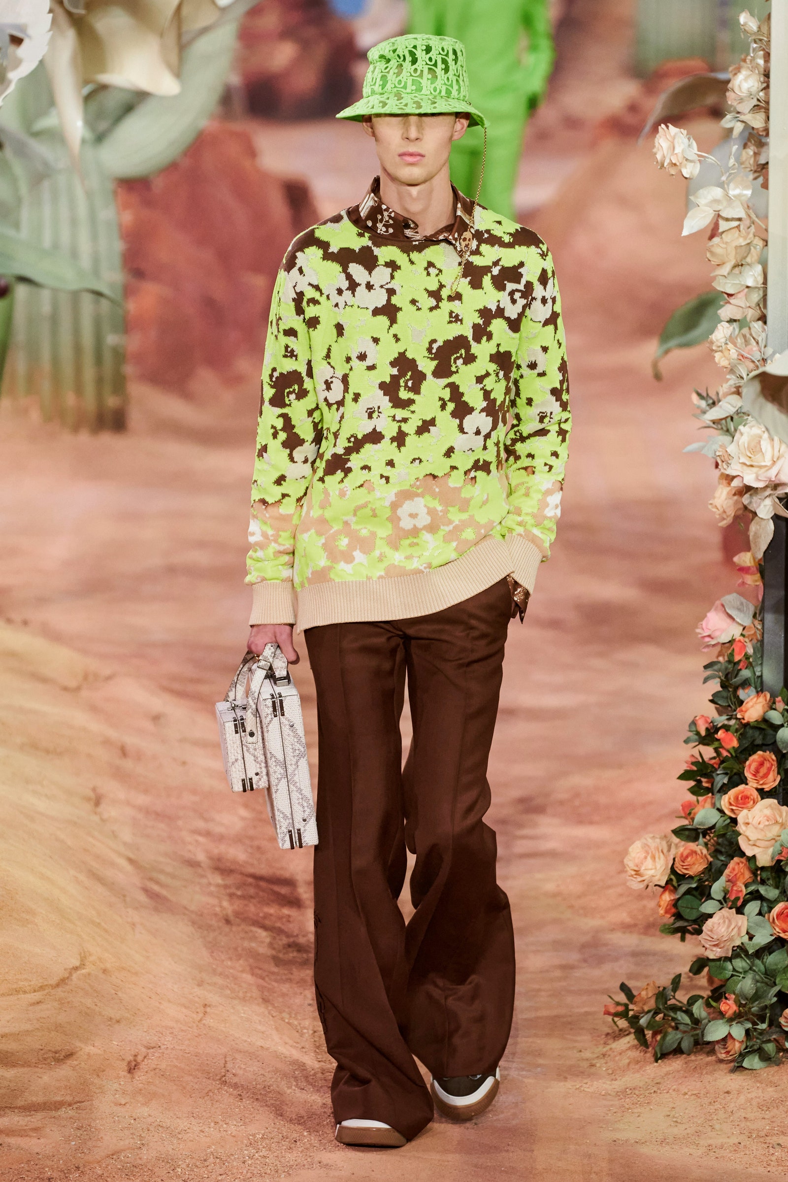 A person wearing a green crotched hat green shirt and brown flared pants