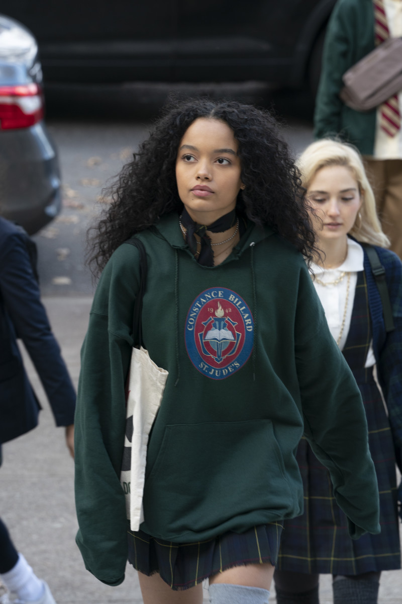 Zoya Lott (Whitney Peak) carries a 'Recycling Black Dollars' tote from Melanin Apparel.