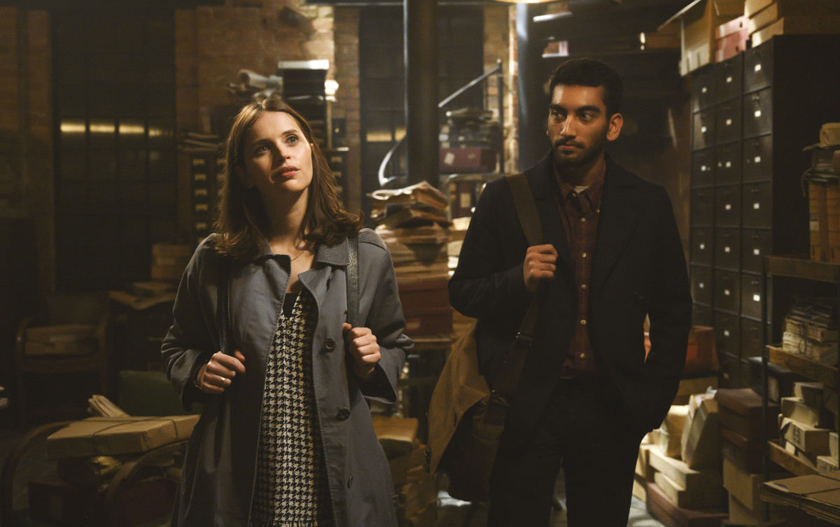 Ellie (Felicity Jones), in Jennifer-reminiscent houndstooth and '60s Burberry jacket, and Rory (Nabhaan Rizwan).