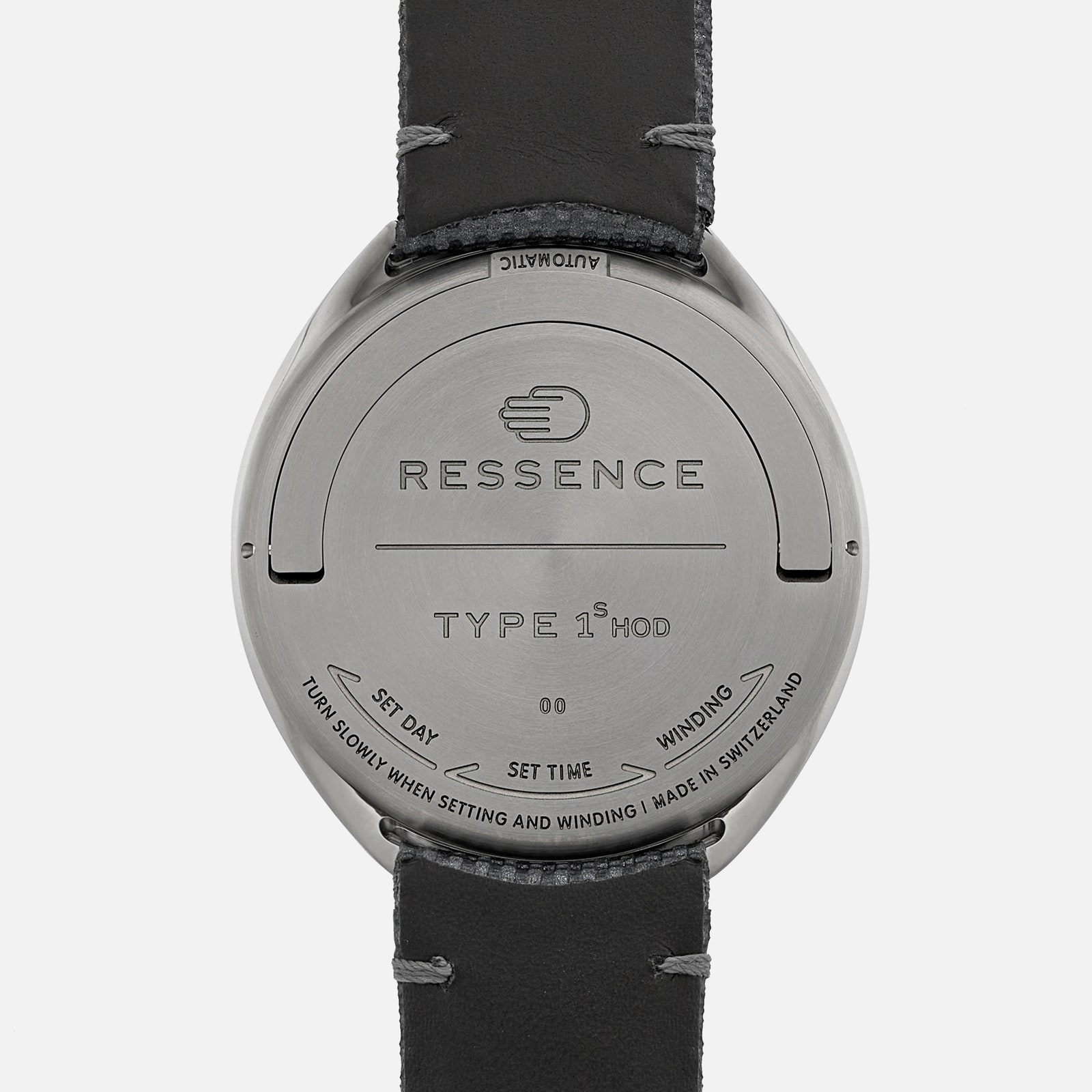 The back of a watch with a hand engraving and RESSENCE TYPE 1 MOD