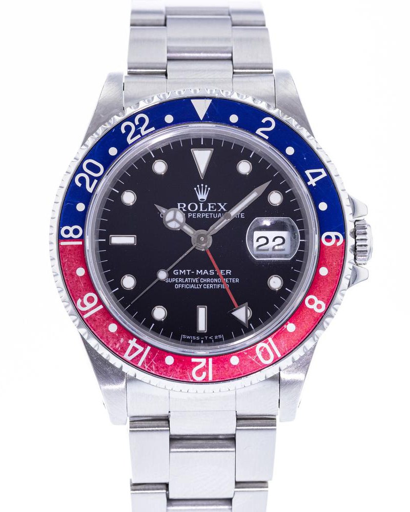 A silver watch with a red and blue bevel and a black face