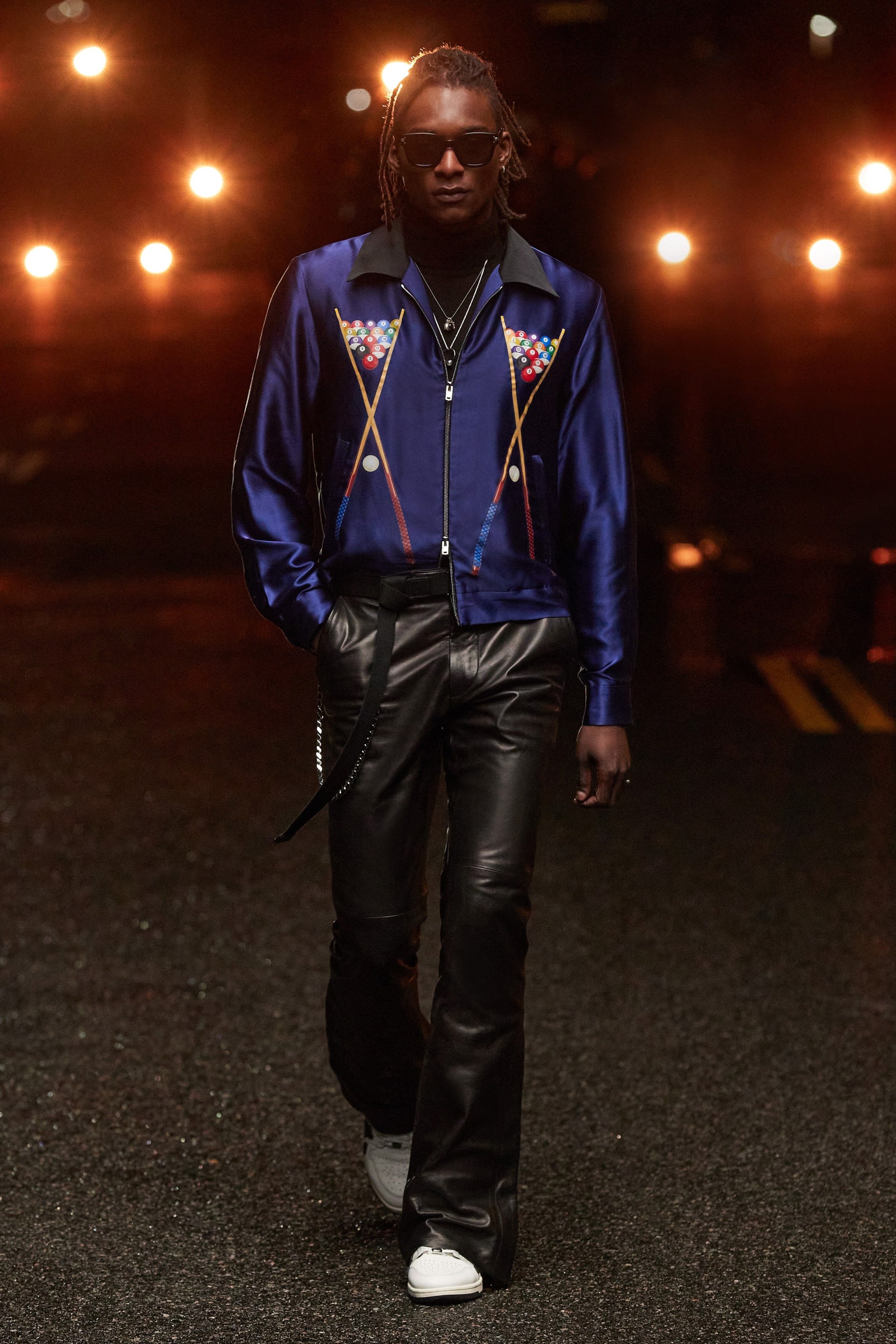 A person wearing a purple shirt and black flared pants