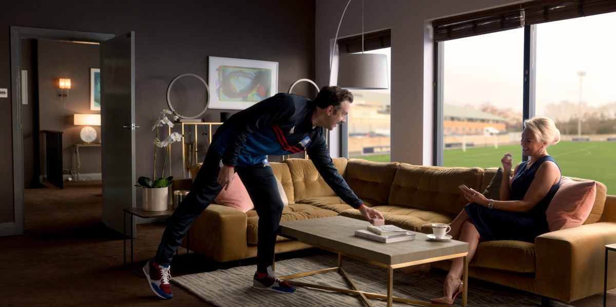 Ted Lasso (Jason Sudeikis) bringing Rebecca (Hannah Waddington) her favorite snack.