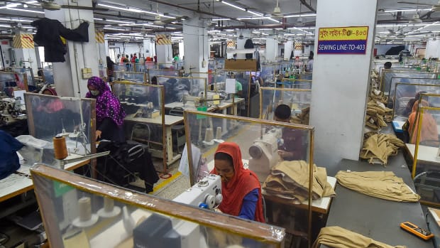 Labourers work at their stations separated by partitions as a preventive measure against the Covid-19 coronavirus at the Civil Engineers Limited garments factory in Dhaka