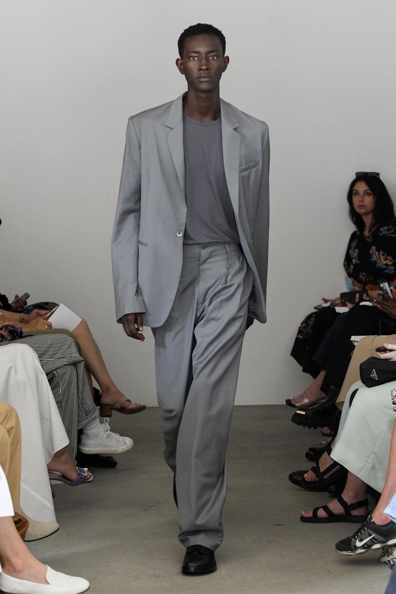 Image may contain Clothing Apparel Suit Coat Overcoat Footwear Shoe Human Person and Tuxedo