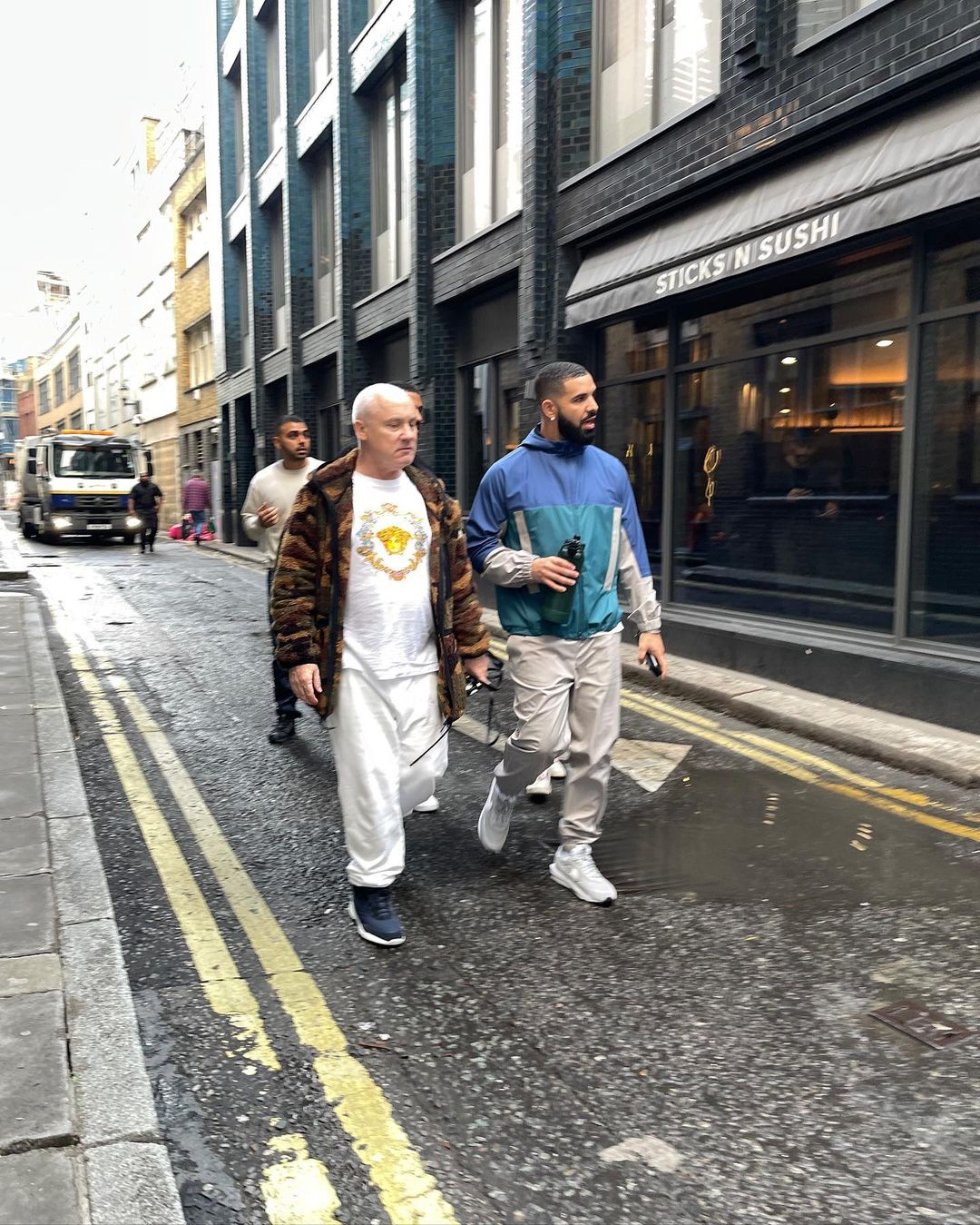 Image may contain Human Pedestrian Person Clothing Shoe Footwear Apparel Asphalt Tarmac Drake Path and Road