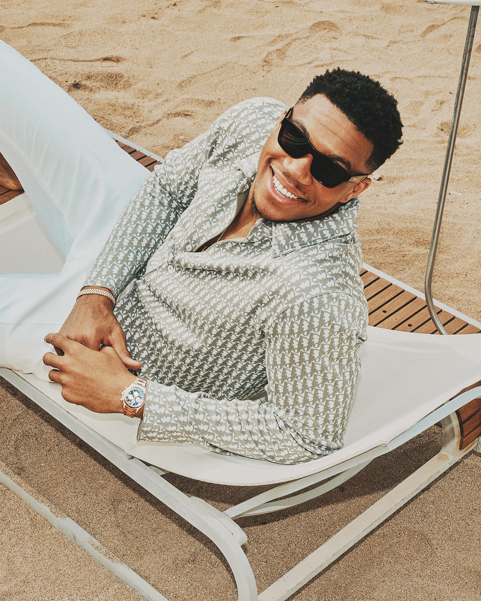 Giannis relaxing on a reclining chair on a beach