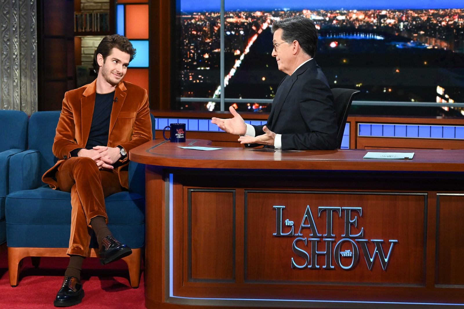 Image may contain Andrew Garfield Furniture Human Person Sitting and Table