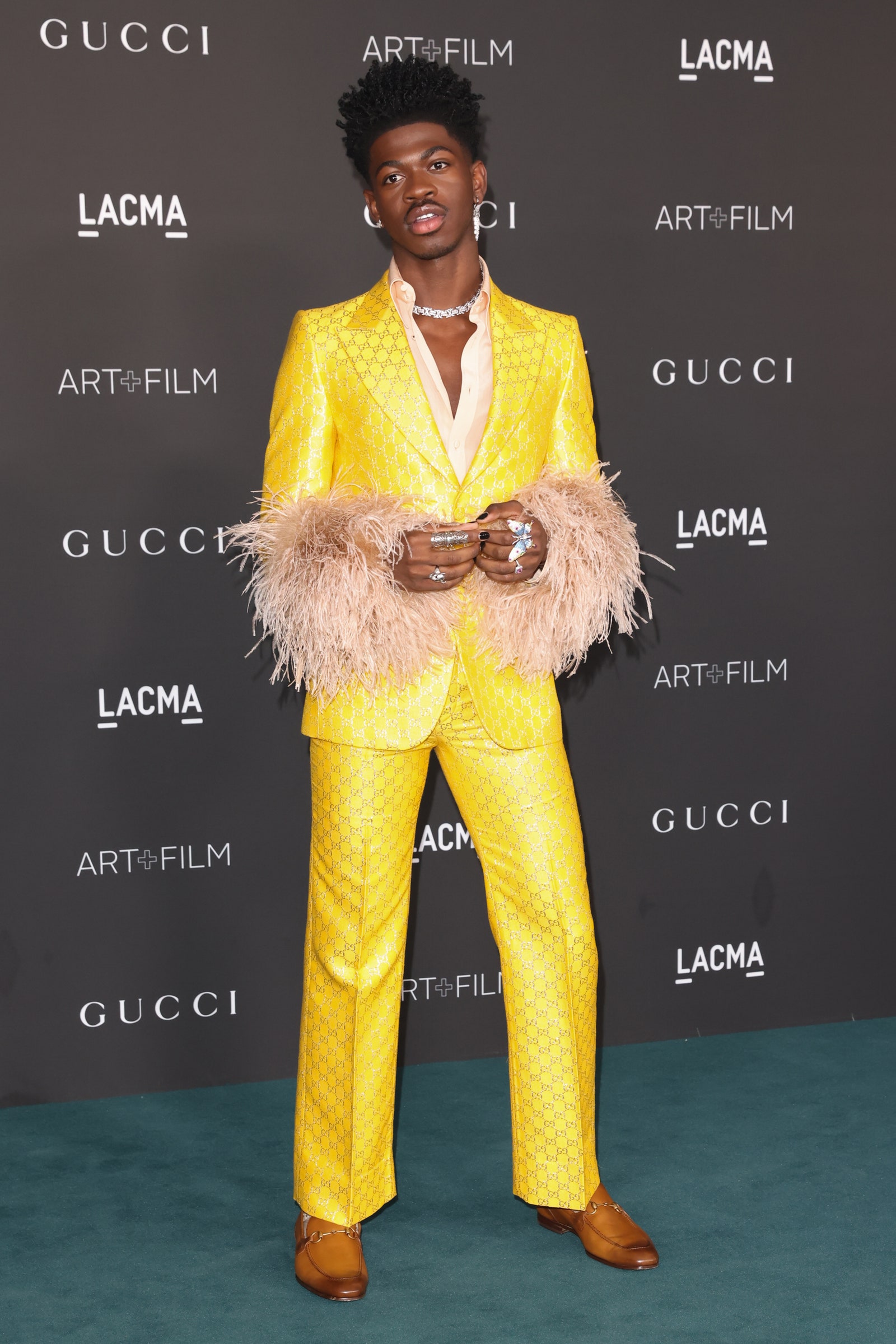 Image may contain Clothing Apparel Human Person Suit Coat Overcoat Performer and Fashion