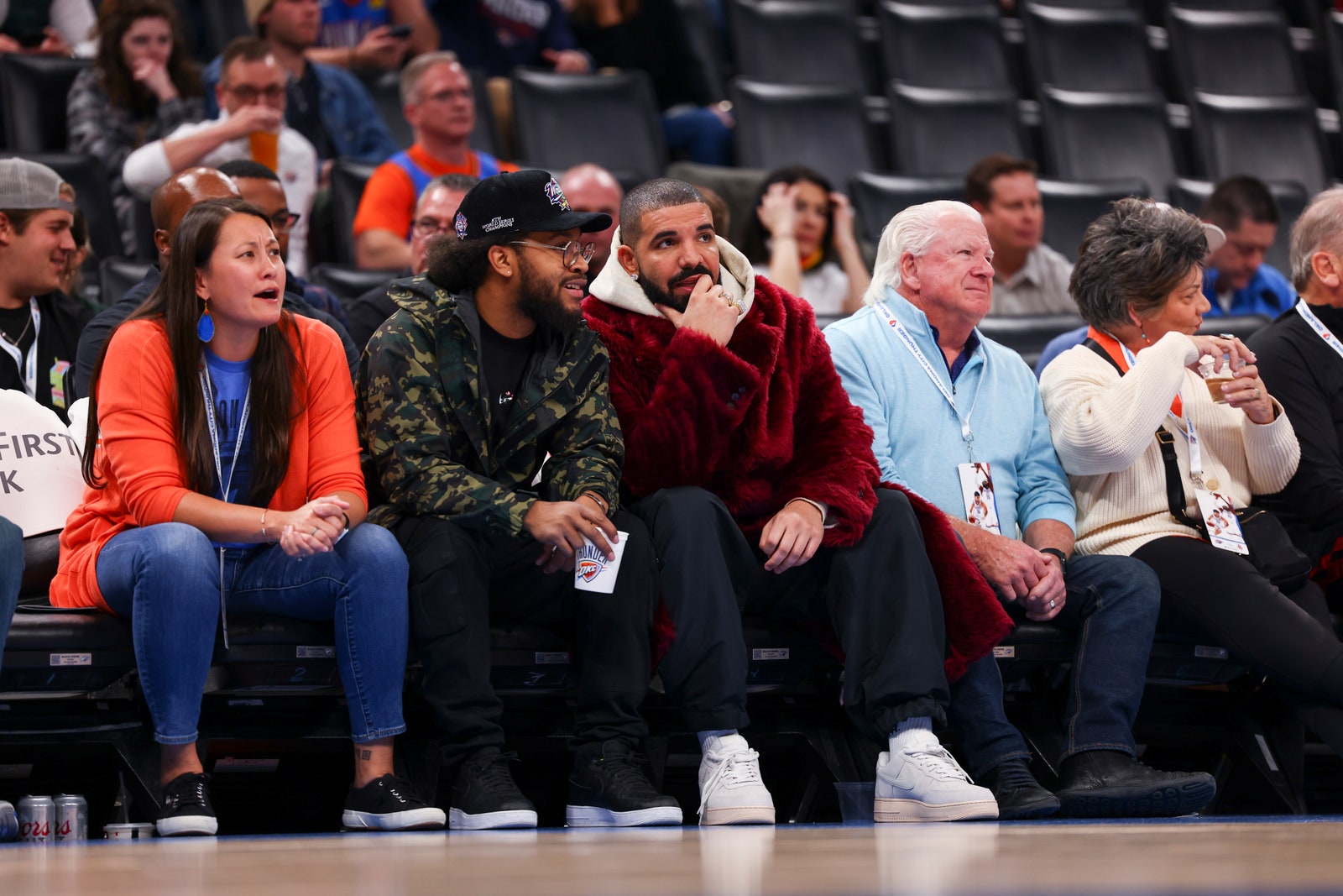 Image may contain Audience Crowd Human Person Clothing Apparel Shoe Footwear Sitting and Drake