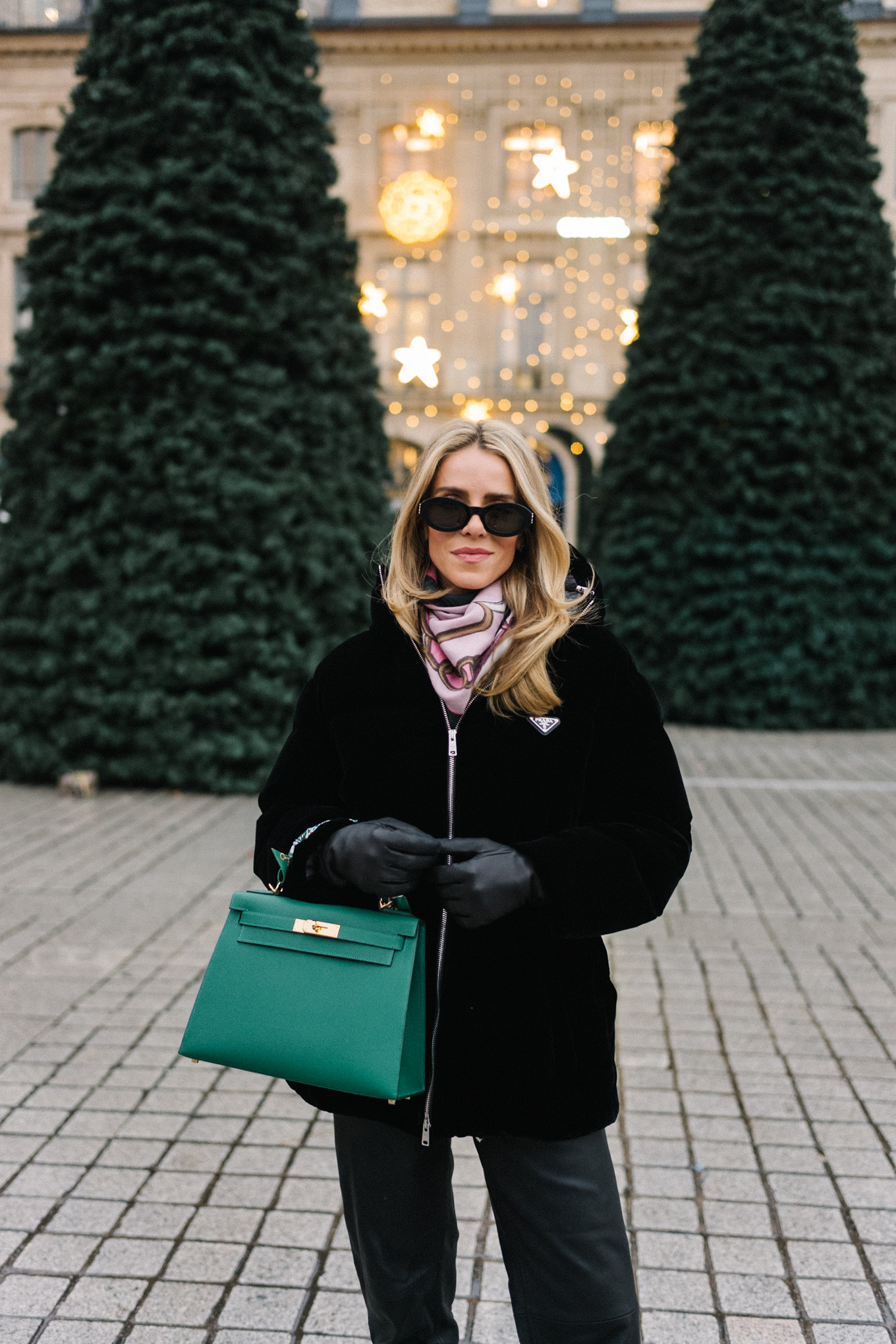 black velvet puffer coat black pants green handbag in paris